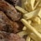 Secreto de cerdo con cebolla dorada a la plancha y patatas fritas caseras