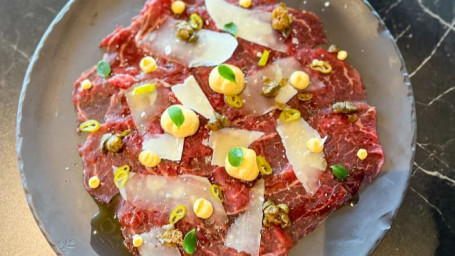 Beef carpaccio with Béarnaise sauce, Parmesan cheese and pickled vegetables.
