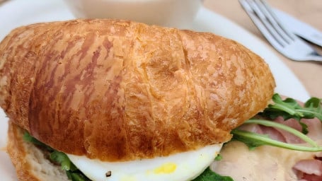 Breakfast Croissant Sandwich With Soft Poached Egg, Savoy Spinach, And Brie Cheese